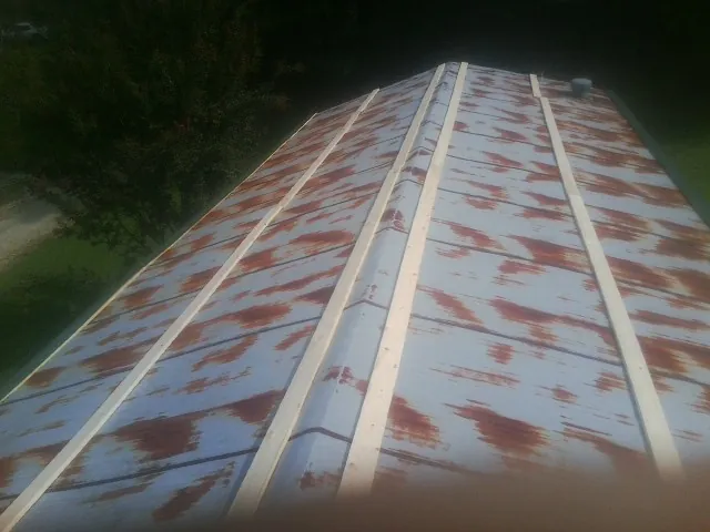 Rusted metal roof panels with new wood purlins before replacement — Storm Damage Roof Repair in Ironside by Roofing Brothers