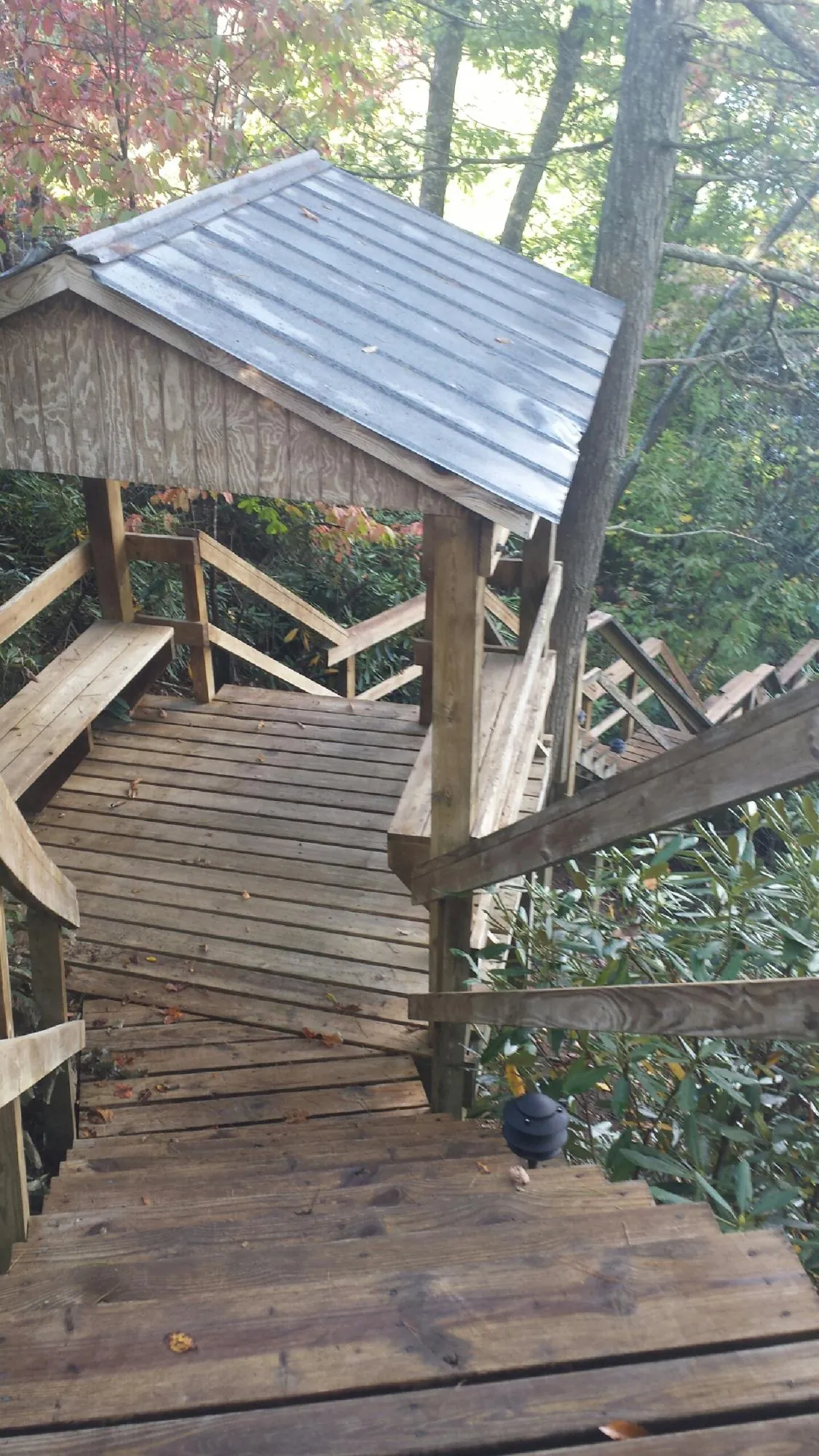 Metal roofed shelter over wooden steps on a wooded walkway — Skylight Repair & Installation work by our crew in Ironside